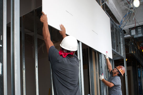 Contractors holding a panel above their heads