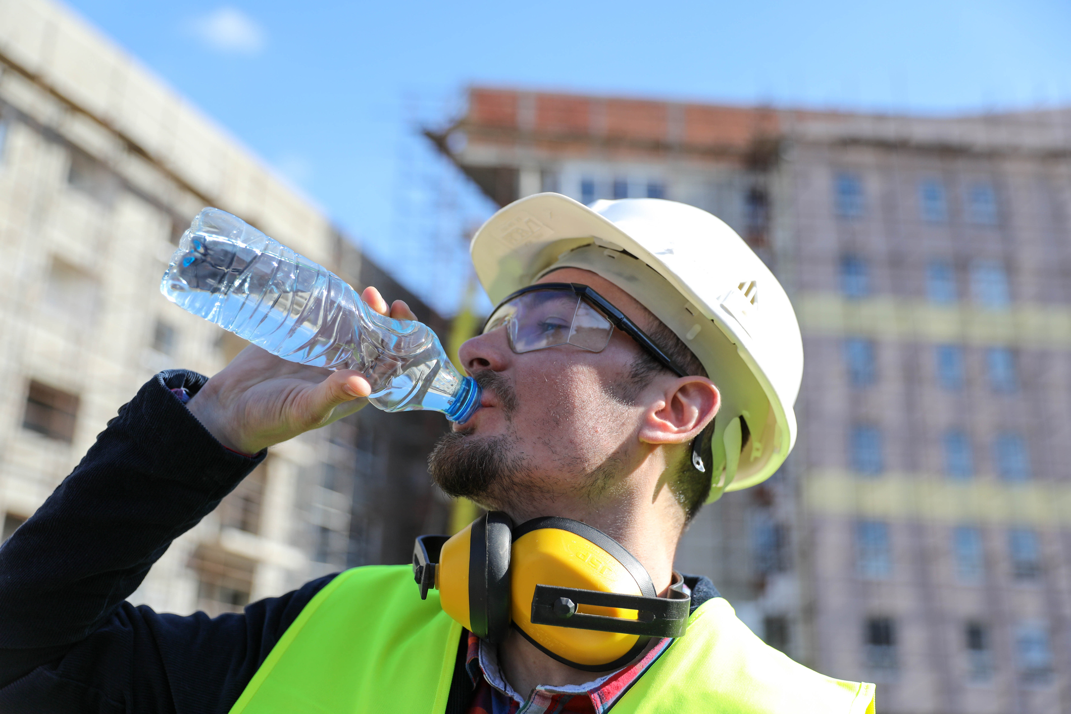 Worker at construction site on a hot day hydrating