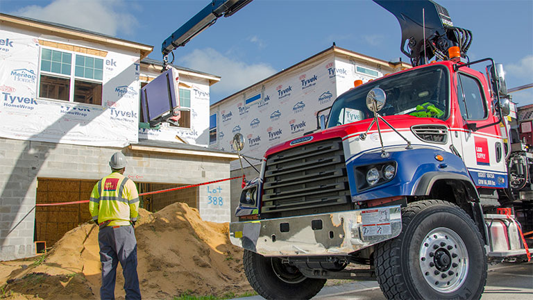 L&W Supply Truck with Crane Delivering Dry Wall to Second Story Window